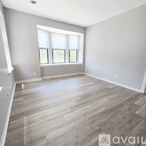 A room with wooden flooring and a window.
