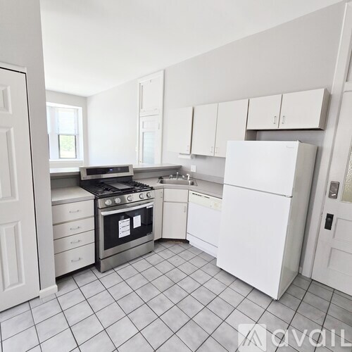 A kitchen with white appliances and a black stove top.
