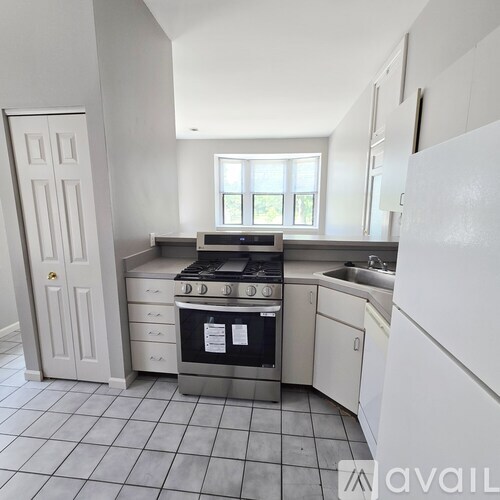 A kitchen with white appliances and a black stove top oven.