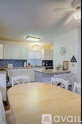 A kitchen with a table and chairs in the foreground.