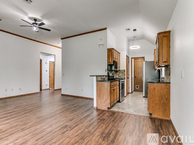 A kitchen with wooden cabinets and a ceiling fan.