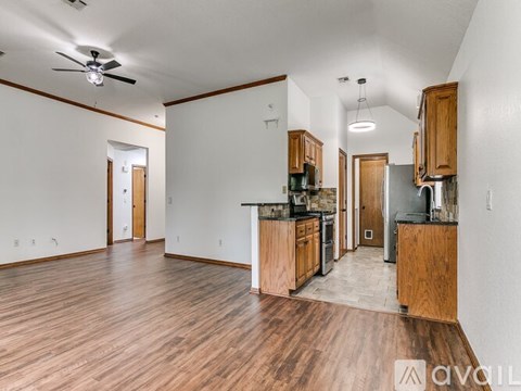 A kitchen with wooden cabinets and a ceiling fan.