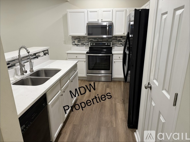 A kitchen with a sink, stove, and refrigerator is available for rent.