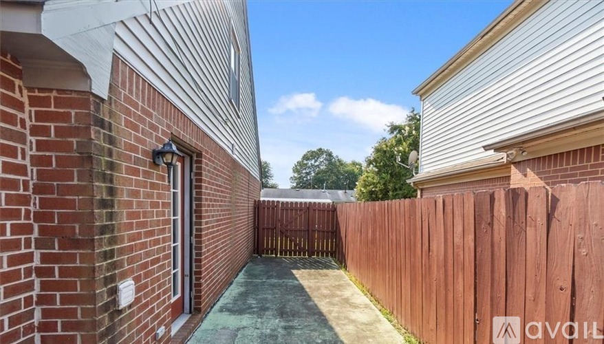 A backyard with a wooden fence and a brick building.