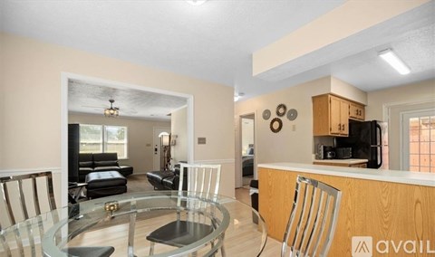 A modern kitchen with a glass table and chairs.