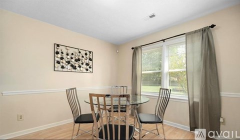 A dining room with a glass table and chairs.