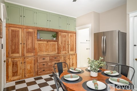 A kitchen with wooden cabinets and a checkered floor.