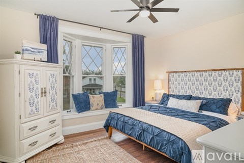 A bedroom with a large bed and a dresser with a mirror.