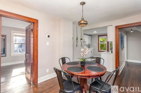 A dining room with a round wooden table and chairs.