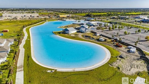 A large blue water body surrounded by buildings and greenery.