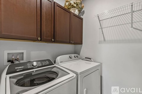 A Whirlpool washing machine and dryer in a laundry room.