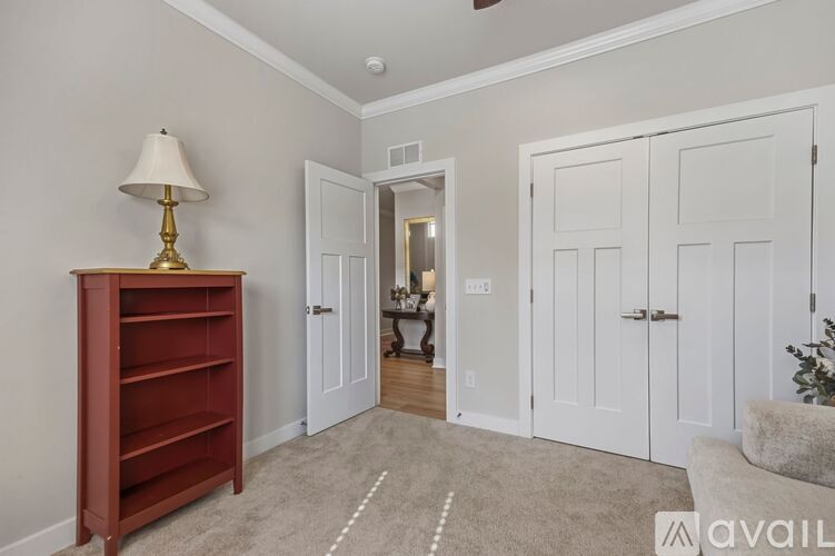 A room with a lamp, a dresser and a couch.