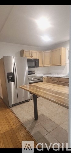 A kitchen with a wooden table and a refrigerator.