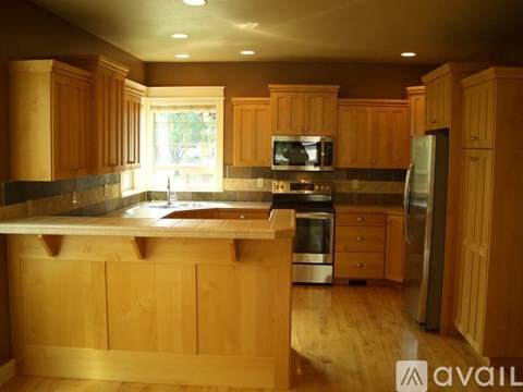 A kitchen with wooden cabinets and a large island.