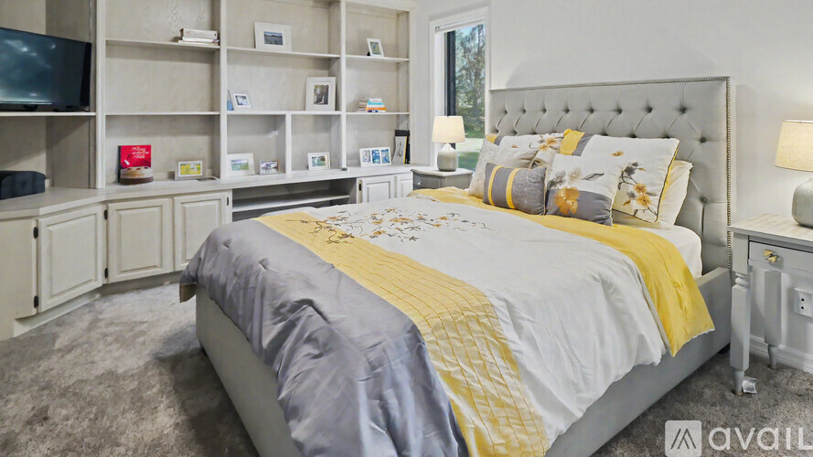 A bedroom with a large bed and a television on the wall.