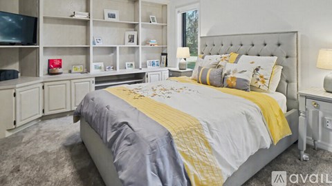 A bedroom with a large bed and a television on the wall.