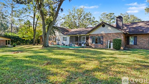 A house with a lawn and trees in front of it.