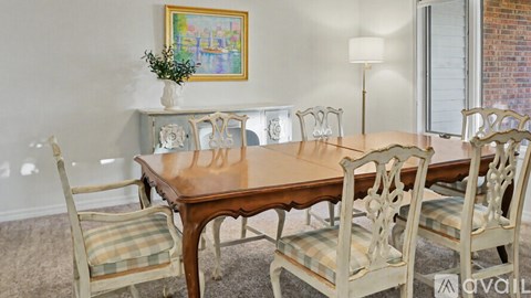 A dining room with a wooden table and chairs.