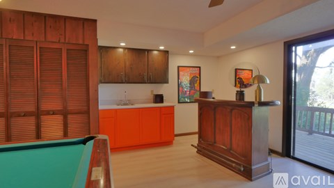 A room with a pool table and a bar.