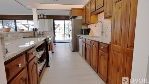 A kitchen with wooden cabinets and a marble countertop.