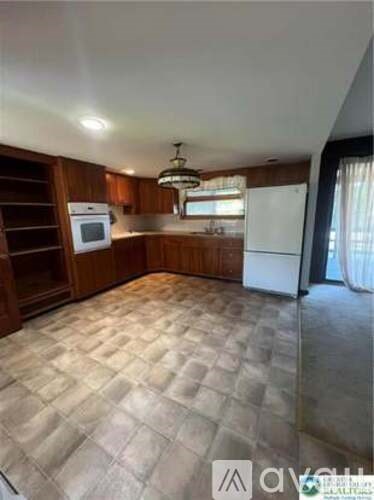 A kitchen with wooden cabinets and a white refrigerator.