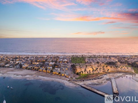 A beautiful aerial view of a coastal town at sunset with boats in the water.