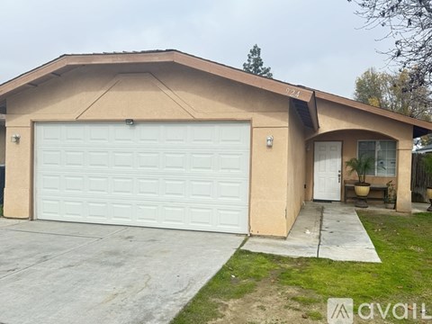 A beige garage with a white door is situated in front of a house.