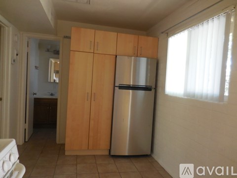 A kitchen with wooden cabinets and a stainless steel refrigerator.