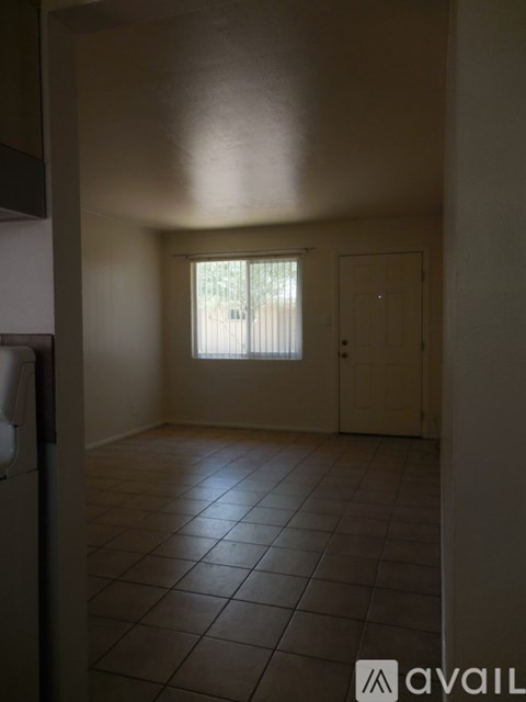 A room with tiled flooring and a window with blinds.