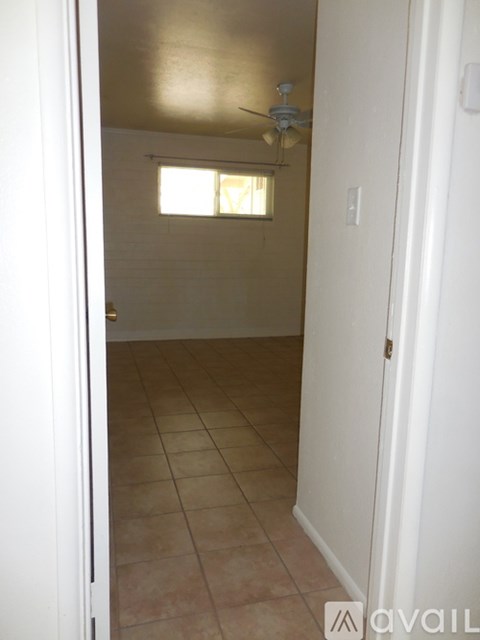 A room with a ceiling fan and a window.