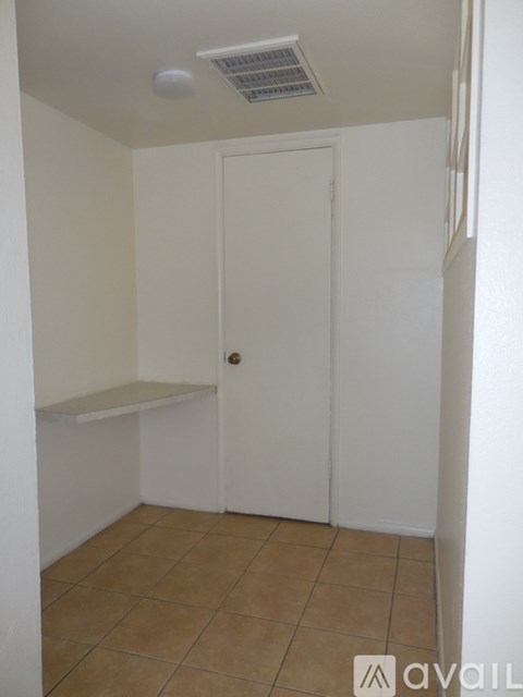 A small room with a white door and a tiled floor.