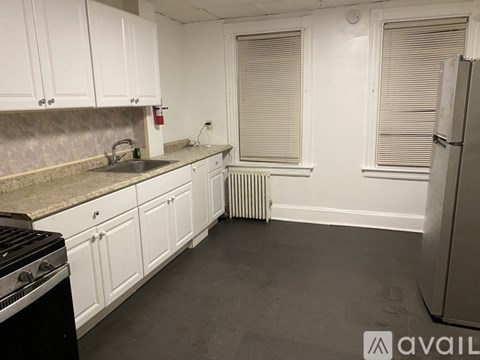 A kitchen with white cabinets and a black stove top.