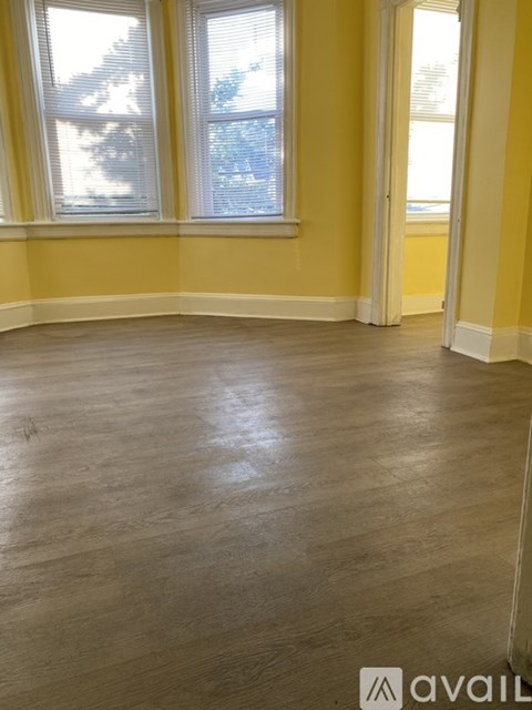 A room with wooden flooring and a window.