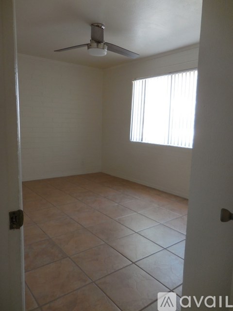 A room with a ceiling fan and tiled floor.