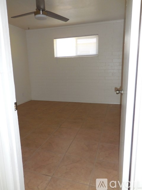 A room with a ceiling fan and a window.