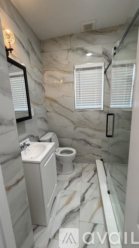 A bathroom with a marble floor and white walls.
