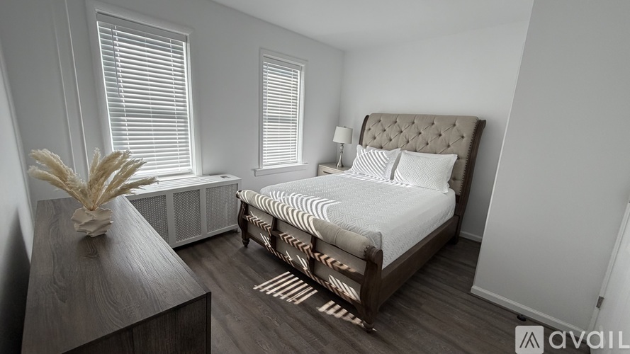 A bedroom with a large bed and a wooden nightstand.