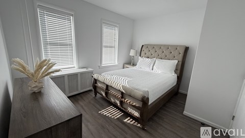 A bedroom with a large bed and a wooden nightstand.