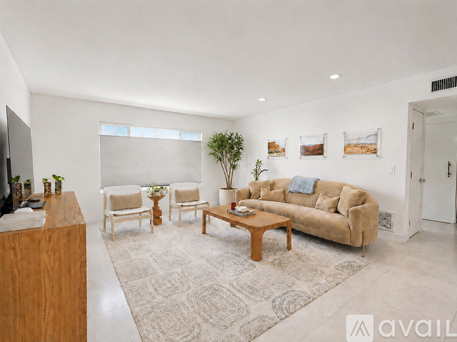 A living room with a couch, chairs, and a coffee table.
