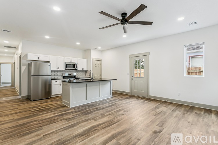 A kitchen with a refrigerator, microwave, and oven.