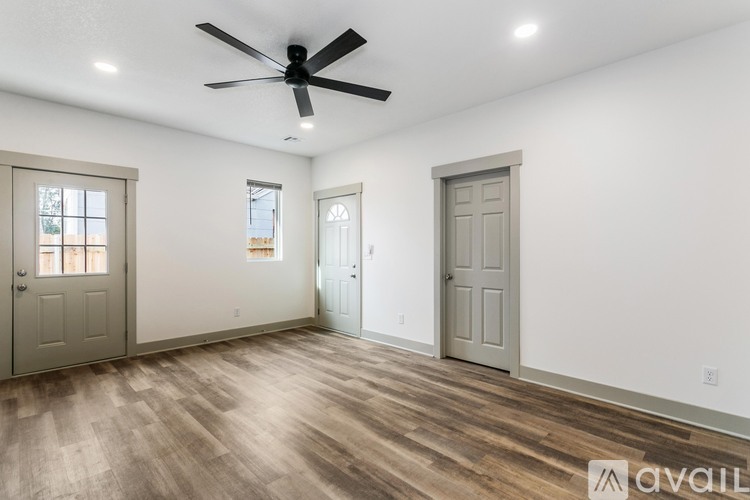 A room with a ceiling fan and wooden flooring.