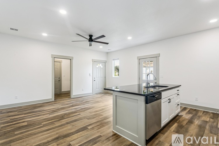 A spacious kitchen with wooden floors and a center island.