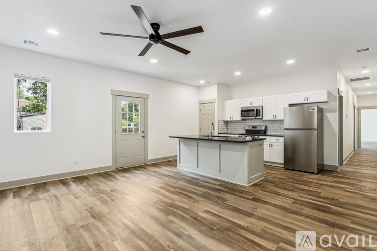 A spacious kitchen with a refrigerator, microwave, and oven.