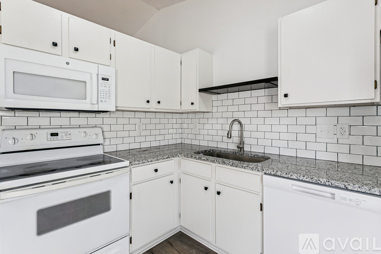 A kitchen with white cabinets and appliances.