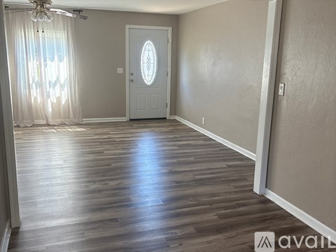 A room with a white door and a ceiling fan.