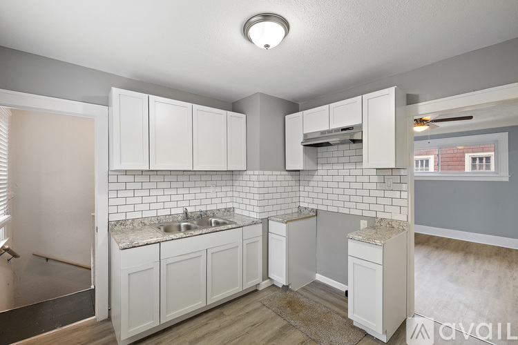 A kitchen with white cabinets and a tiled backsplash.