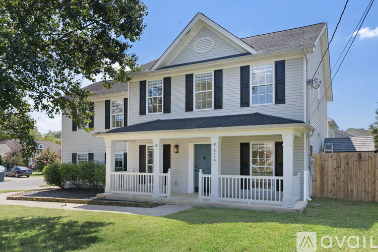 A white house with black shutters and a porch.