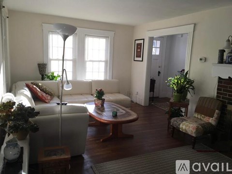 A living room with a white couch, a coffee table, and a lamp.