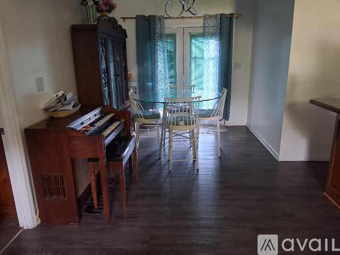 A room with a piano and chairs.