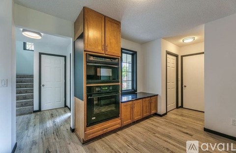 A kitchen with wooden cabinets and a stainless steel oven.